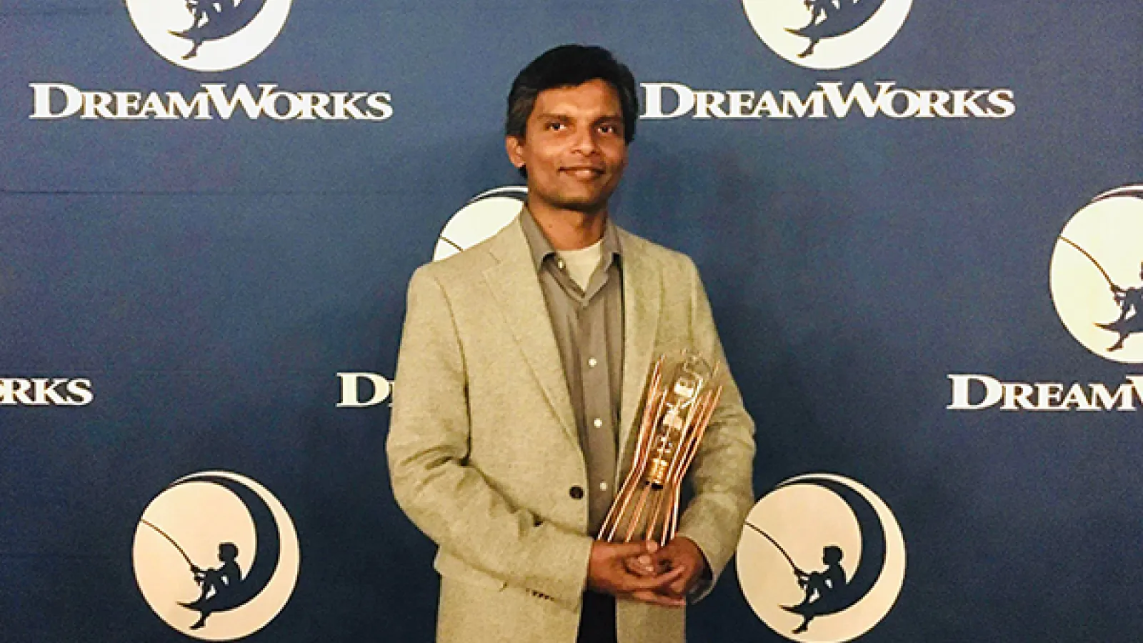 A photo of Lakshika Udakandage holding his Ingenuity Award from DreamWorks