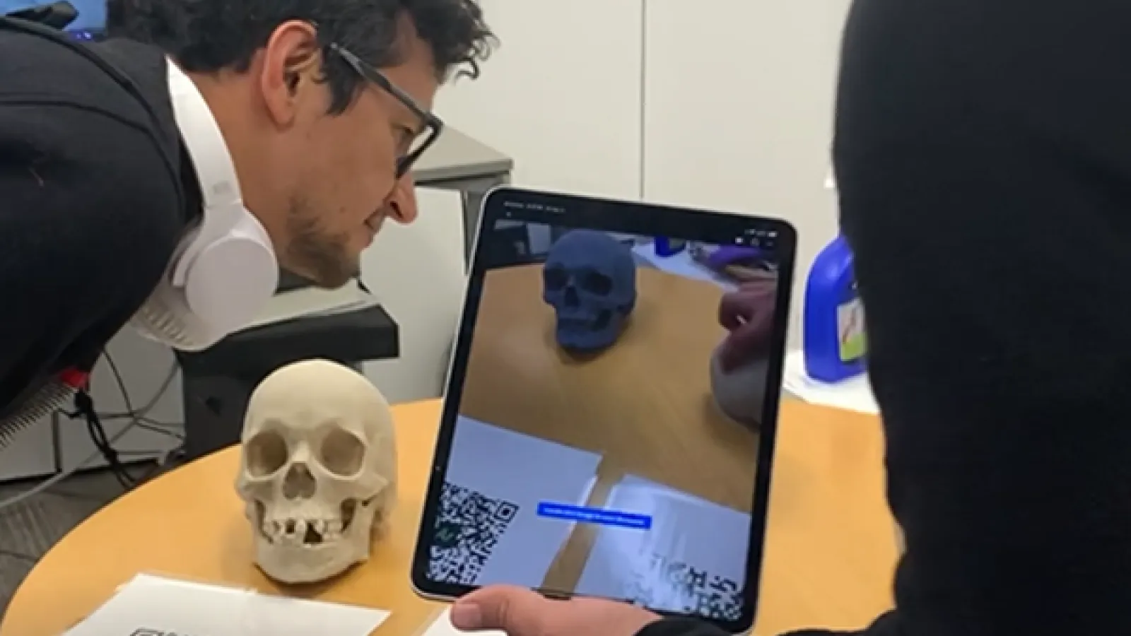 Two men looking at an iPad to view an AR experience.